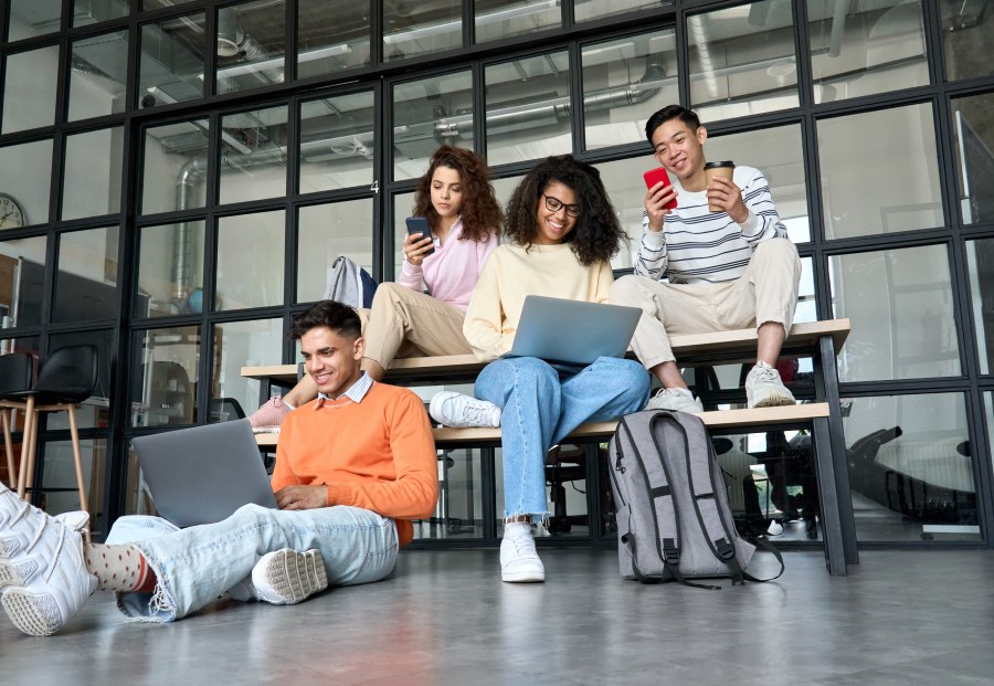 Grupo de jóvenes de la generación Z realizando búsquedas en sus móviles y ordenadores