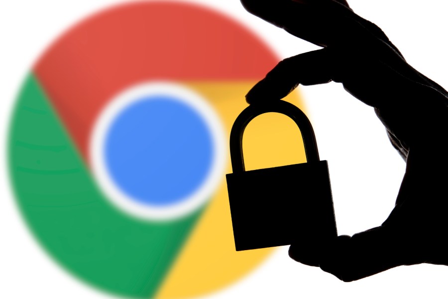 Una mano sostiene un candado frente al logo de Google Chrome