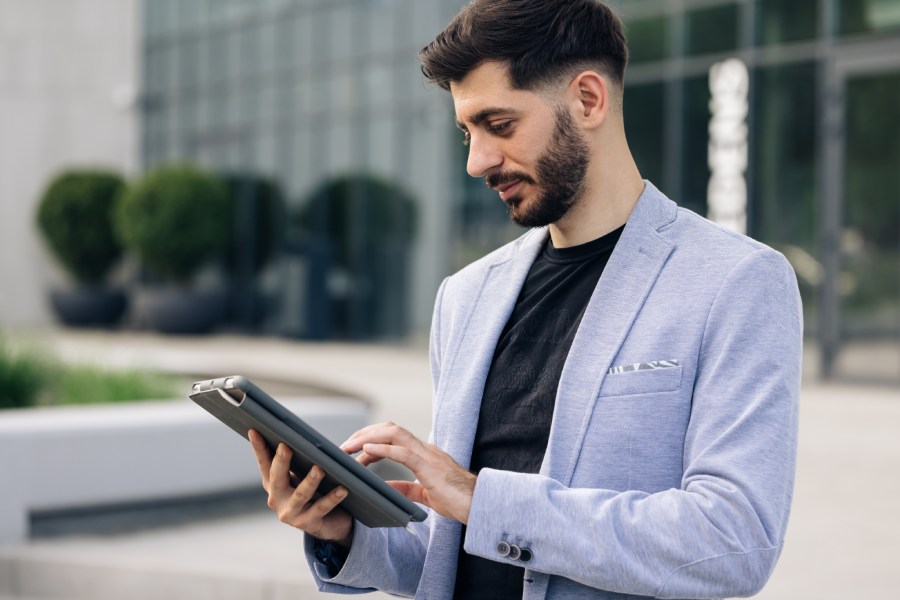 Un hombre trabaja con una Tablet al aire libre 