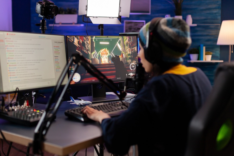 Una gamer frente a un ordenador compite en un videojuego mientras retransmite en una plataforma de streaming